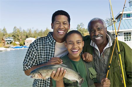 simsearch:694-03318999,k - Male members of three generation family showing fish, smiling, (portrait) Fotografie stock - Premium Royalty-Free, Codice: 693-03299584