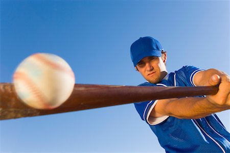 Baseball player hitting ball with bat, (low angle view) Foto de stock - Sin royalties Premium, Código: 693-03299593