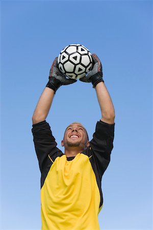 Goalkeeper catching soccer ball, portrait Stock Photo - Premium Royalty-Free, Code: 693-03299639