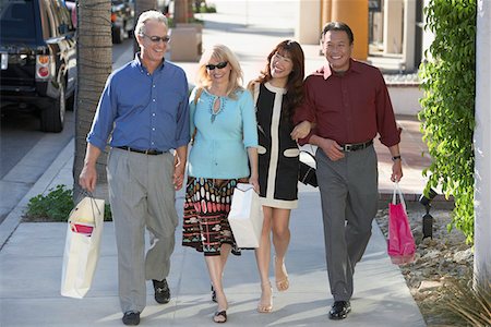 simsearch:693-03565485,k - Couples walking arm in arm, holding hands outdoors on Shopping Trip Foto de stock - Sin royalties Premium, Código: 693-03299656