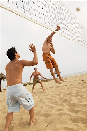 Man in Mid-air Going for Volleyball on beach Fotografie stock - Premium Royalty-Free, Codice: 693-03299668