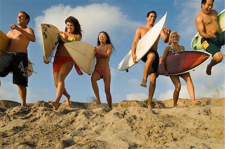 surfer running - Six surfers carrying surfboards, running on beach, low angle view Stock Photo - Premium Royalty-Free, Code: 693-03299696