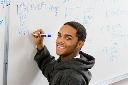 Male student writing equations on whiteboard, (portrait) Stock Photo - Premium Royalty-Free, Code: 693-03299766