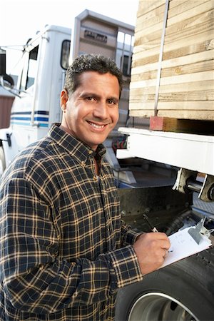 Man with clipboard by truck loaded with wood Stock Photo - Premium Royalty-Free, Code: 693-03299894