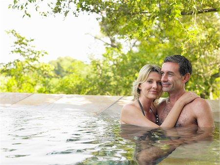 Portrait of adult couple embracing in pool, smiling Stock Photo - Premium Royalty-Free, Code: 693-03304043