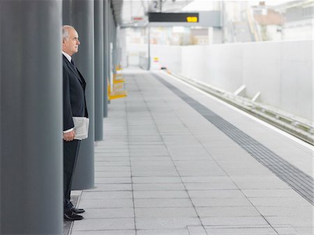 simsearch:693-03311596,k - Homme d'affaires mature debout, attendant à vide de la gare, vue latérale Photographie de stock - Premium Libres de Droits, Code: 693-03304116