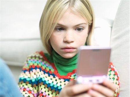 simsearch:693-03309303,k - Young Girl concentrating, Playing Handheld Video Game Stock Photo - Premium Royalty-Free, Code: 693-03304179