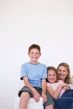 Portrait of mother and children sitting on couch in weather boarded room Stock Photo - Premium Royalty-Free, Code: 693-03304258