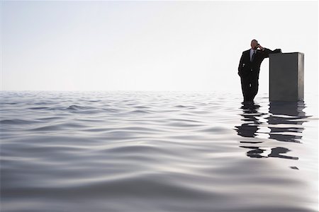 deep ocean - Business man leaning on filing cabinet standing in sea Stock Photo - Premium Royalty-Free, Code: 693-03304362