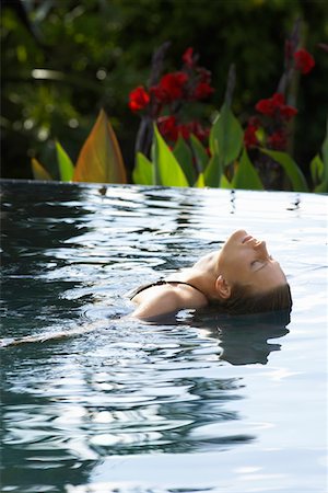 Young woman leaning backwards in natural swimming pool, portrait Stock Photo - Premium Royalty-Free, Code: 693-03304418