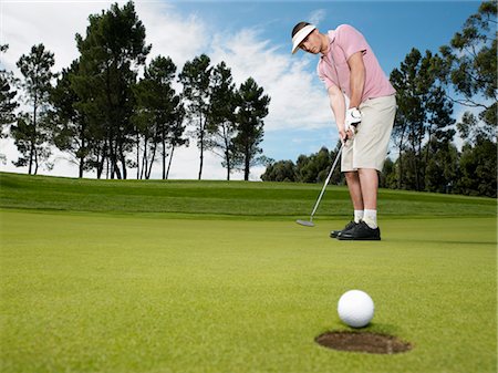 Golfer putting, low angle view Stock Photo - Premium Royalty-Free, Code: 693-03304425