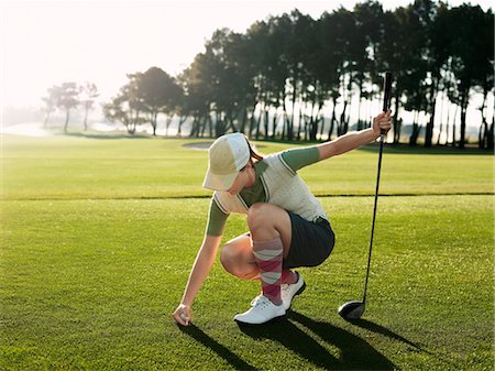 simsearch:693-03304456,k - Young female golfer placing ball on tee Foto de stock - Sin royalties Premium, Código: 693-03304462