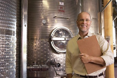 simsearch:693-03305464,k - Portrait of winemaker standing next to wine vat holding clipboard Stock Photo - Premium Royalty-Free, Code: 693-03304571