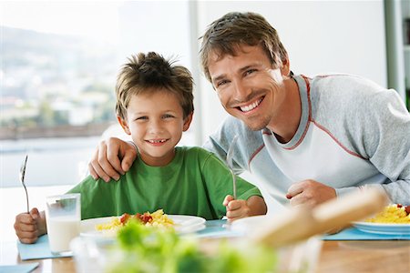 family around a table eating pasta - Father and son sitting at table eating pasta Stock Photo - Premium Royalty-Free, Code: 693-03304585