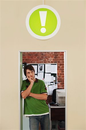 exclamation - Young man standing in doorway of office, with sign of exclamation mark above. Stock Photo - Premium Royalty-Free, Code: 693-03304659