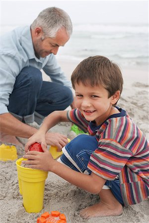 sand castle and parent and child - Father and son (5-6) playing in sand on beach Stock Photo - Premium Royalty-Free, Code: 693-03304696