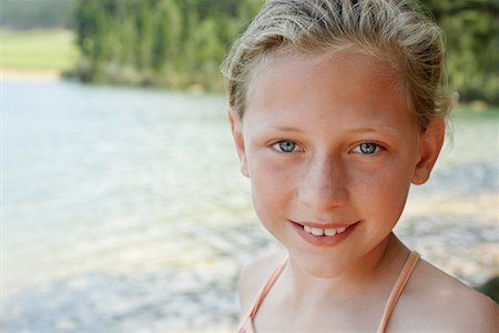 Girl (7-9) standing by lake, portrait. Stock Photo - Premium Royalty-Free, Code: 693-03304759