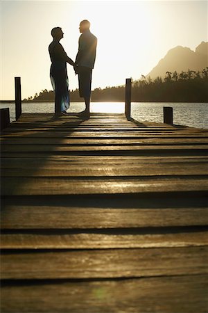 simsearch:693-03304775,k - Couple standing on dock by lake, holding hands, side view. Stock Photo - Premium Royalty-Free, Code: 693-03304777