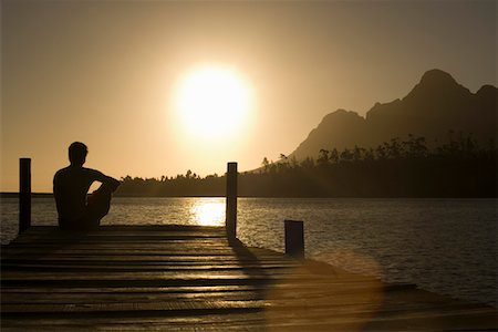 silhouette people sitting on a dock - Man sitting on dock by lake, back view. Foto de stock - Sin royalties Premium, Código: 693-03304779