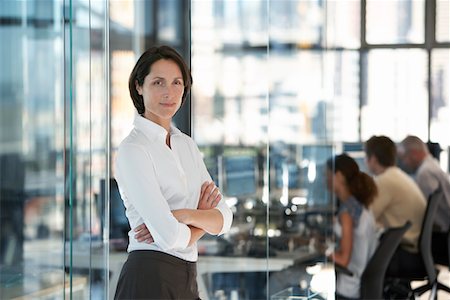 simsearch:693-03303488,k - Businesswoman standing in office with group of office workers in background. Foto de stock - Sin royalties Premium, Código: 693-03304818