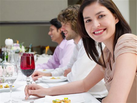 portrait of wedding party - Young woman in dress sitting at table of formal dinner party, side view Stock Photo - Premium Royalty-Free, Code: 693-03304925