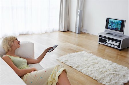 relaxing wood floor guy - Woman lying on sofa, watching television Stock Photo - Premium Royalty-Free, Code: 693-03305095