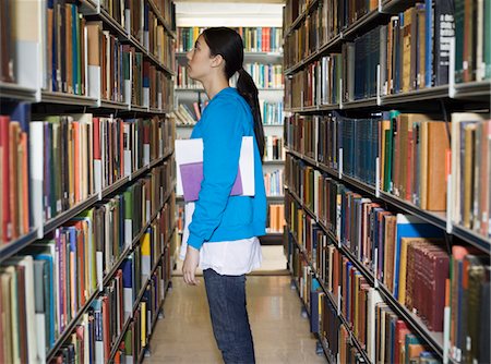 public library - Young woman standing by bookshelf in library Stock Photo - Premium Royalty-Free, Code: 693-03305179