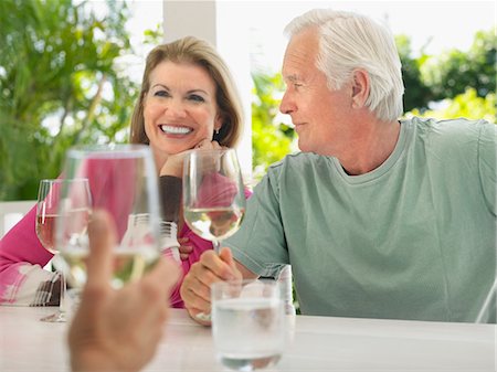 simsearch:693-03305464,k - Three people sitting at verandah, holding wine glasses Stock Photo - Premium Royalty-Free, Code: 693-03305430