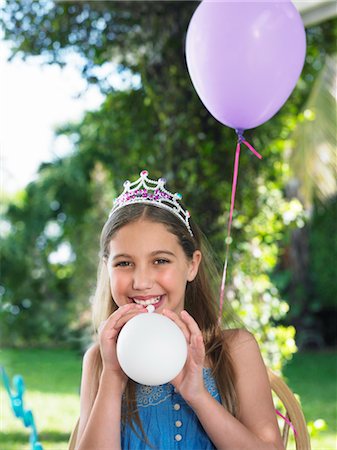 Portrait of young girl (10-12) wearing tiara, blowing up balloons Stock Photo - Premium Royalty-Free, Code: 693-03305579