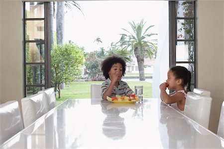 Girl and boy (5-6 years) eating at dining table Stock Photo - Premium Royalty-Free, Code: 693-03305705