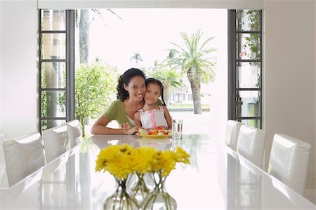 sophisticated home smile - Mother and daughter (5-6 years) sitting at dining table Stock Photo - Premium Royalty-Free, Code: 693-03305701