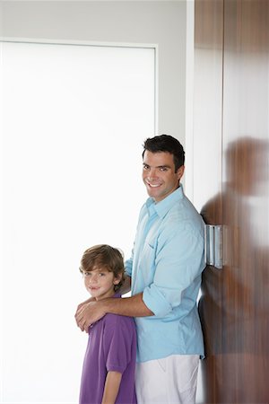 Father and son (7-9) leaning on wardrobe and smiling Foto de stock - Sin royalties Premium, Código: 693-03305747