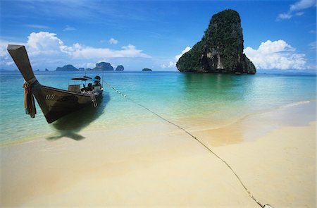 Boat on beach, lone rock formation in background Foto de stock - Royalty Free Premium, Número: 693-03305936