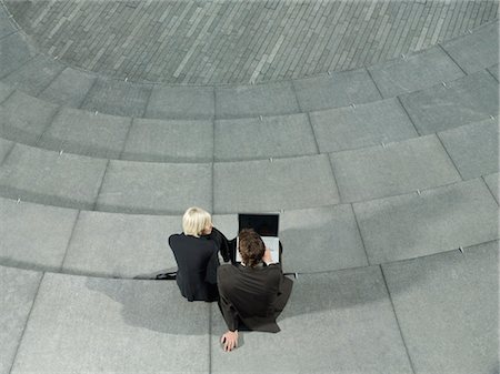 people spiral - Business man and woman sitting on spiral stairs, using laptop, elevated & back view Stock Photo - Premium Royalty-Free, Code: 693-03306277