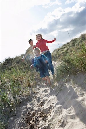 dunes family - Parents and daughter (5-6) running through sand dunes Stock Photo - Premium Royalty-Free, Code: 693-03306624