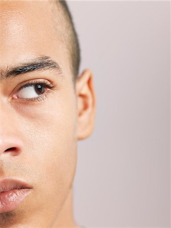 face close up young man looking sideways - Young man looking to side, close-up of face (cropped) Stock Photo - Premium Royalty-Free, Code: 693-03306729