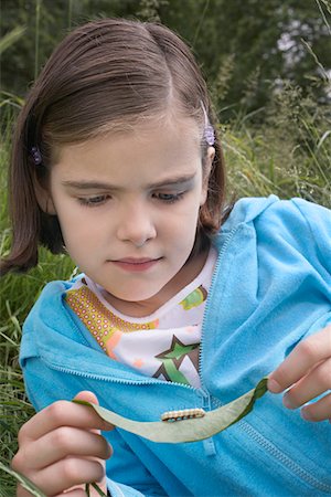 Girl (7-9) examining caterpillar on leaf in field Stock Photo - Premium Royalty-Free, Code: 693-03306958