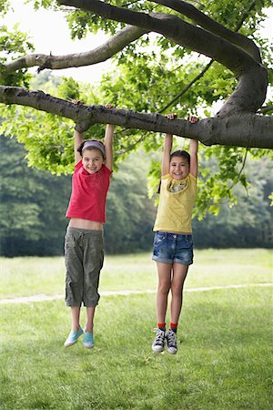 Two girls (7-9) hanging from tree Stock Photo - Premium Royalty-Free, Code: 693-03306989