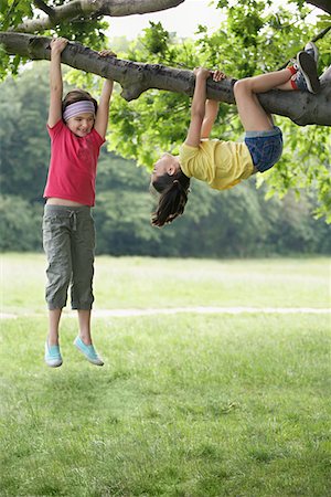 Two girls (7-9) climbing in tree Stock Photo - Premium Royalty-Free, Code: 693-03306990