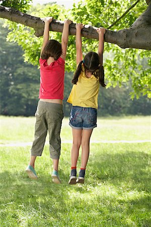 Two girls (7-9) hanging from tree Stock Photo - Premium Royalty-Free, Code: 693-03306992