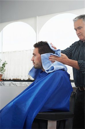 Barber preparing man for haircut in barber shop Stock Photo - Premium Royalty-Free, Code: 693-03307122