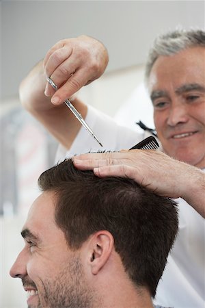 simsearch:693-03307097,k - Barber cutting mans hair in barber shop, close-up Foto de stock - Royalty Free Premium, Número: 693-03307138