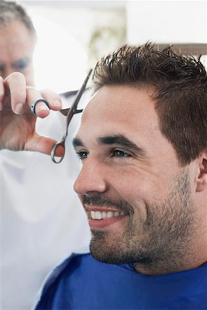 Barber cutting mans hair in barber shop, close-up Foto de stock - Royalty Free Premium, Número: 693-03307132