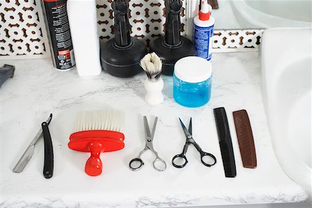 Scissors, combs, razor, brush and hair products on counter in barber shop Foto de stock - Royalty Free Premium, Número: 693-03307162