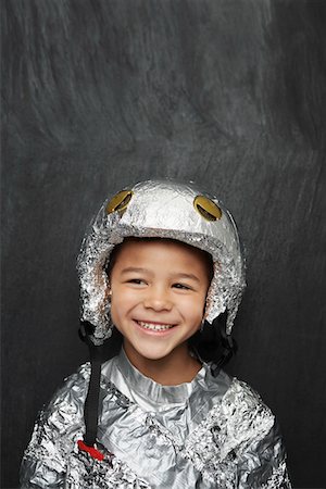 Portrait de jeune garçon (5-6) en costume d'astronaute en aluminium foil, souriant, studio shot Photographie de stock - Premium Libres de Droits, Code: 693-03307212