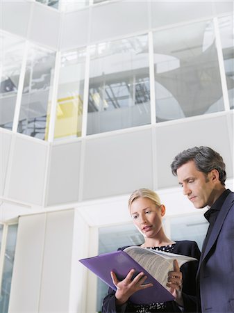 simsearch:693-03311509,k - Two business people looking at paper folder, low angle view Stock Photo - Premium Royalty-Free, Code: 693-03307374