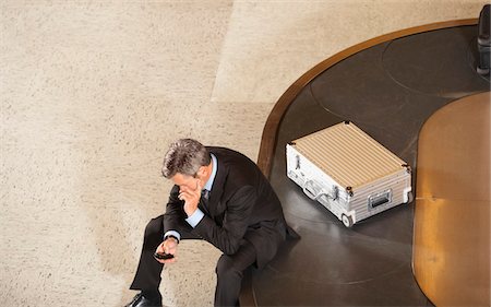 Geschäftsmann, Blick auf Handy sitzen auf Gepäck Karussell in Flughafen Stockbilder - Premium RF Lizenzfrei, Bildnummer: 693-03307654