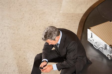 Geschäftsmann mit Handy sitzen auf Gepäck Karussell in Flughafen Stockbilder - Premium RF Lizenzfrei, Bildnummer: 693-03307655