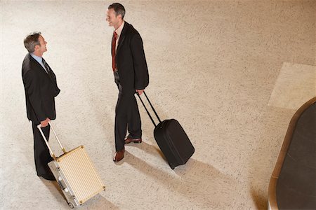 pictures of two people talking at the airport - Two business men standing with suitcases by luggage carousel in airport Stock Photo - Premium Royalty-Free, Code: 693-03307666