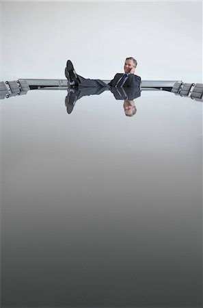 feet up on a boardroom table - Business man with feet up on table in conference room Stock Photo - Premium Royalty-Free, Code: 693-03307692